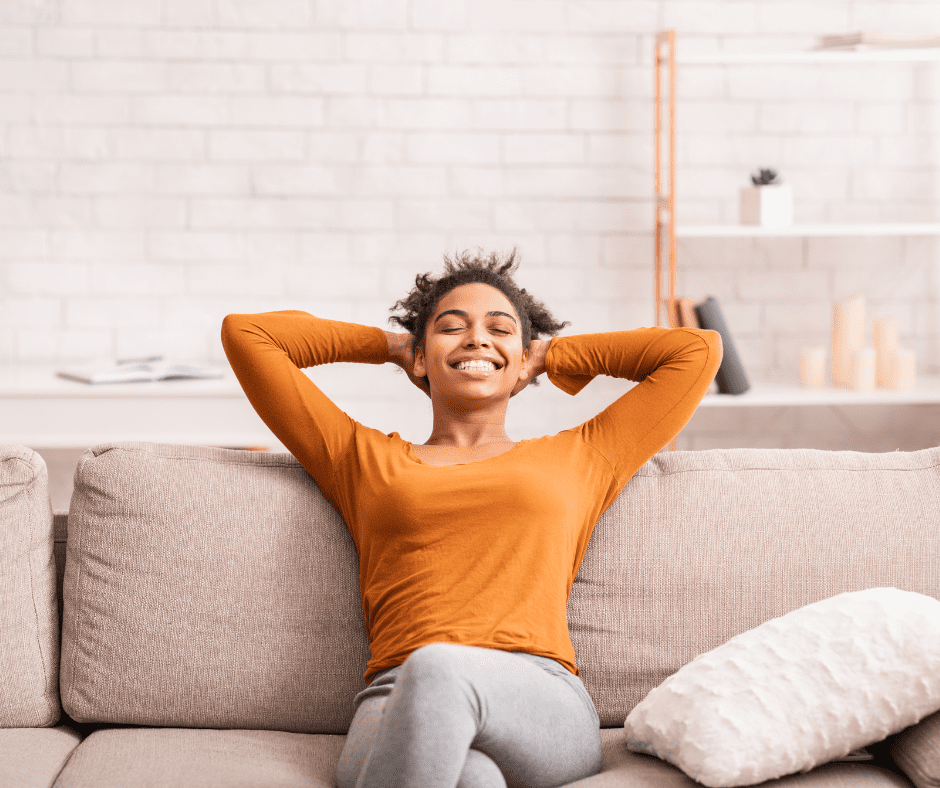 Woman lounging on couch in her climate controlled home. 