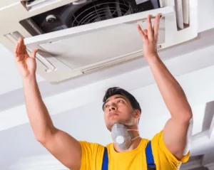 HVAC technician works on a ceiling unit